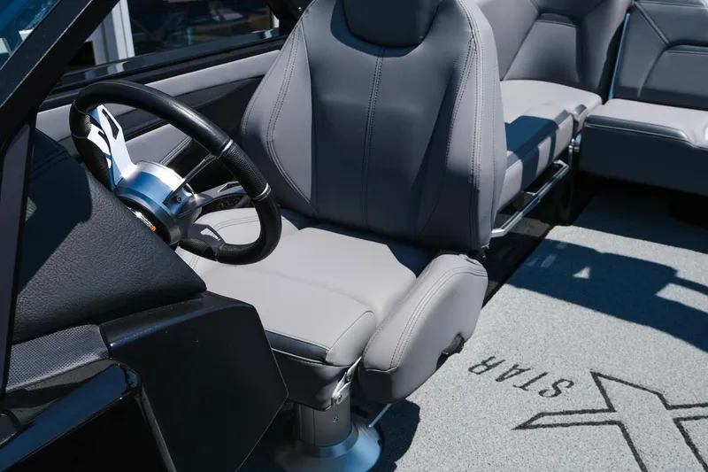Slide: The Image of 2023 MasterCraft XStar interior with sleek gray seating and modern steering wheel design. - 18