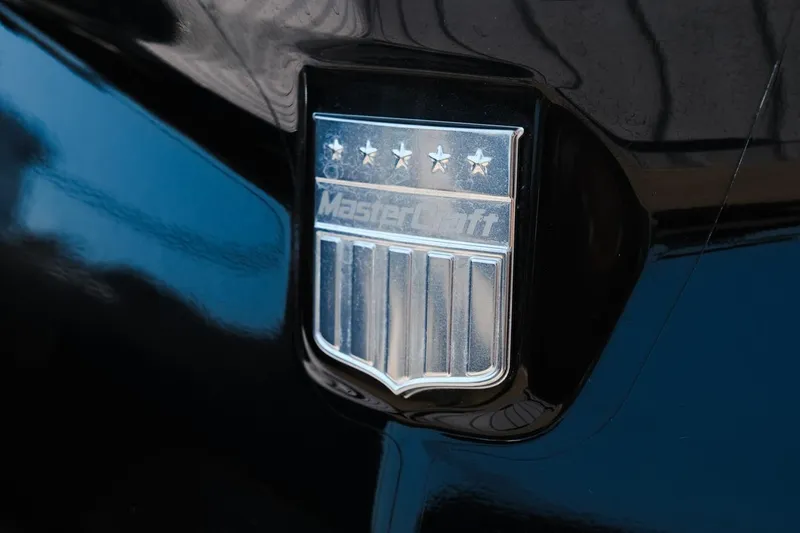 Slide: The Image of 2023 MasterCraft XStar emblem on sleek black surface. - 29