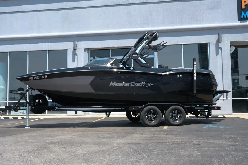 Slide: The Image of 2023 MasterCraft XStar boat on trailer, parked outside a building. - 3