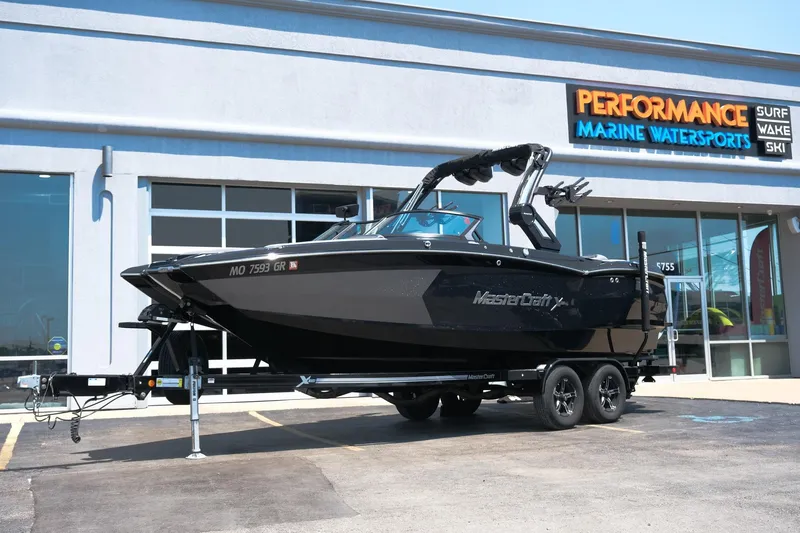 Slide: The Image of 2023 MasterCraft XStar boat on trailer outside Performance Marine Watersports store. - 33