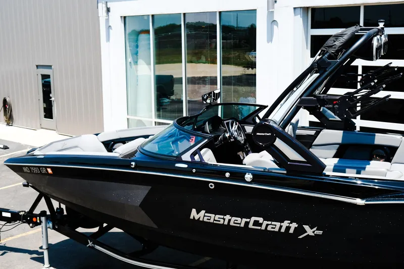 Slide: The Image of 2023 MasterCraft XStar boat parked outside a modern building. - 4