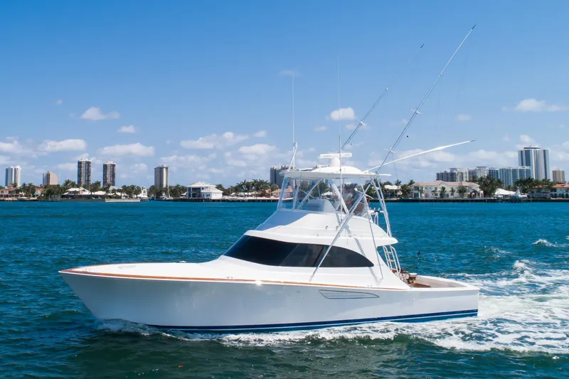 Slide: The Image of 2023 Viking 46 Billfish yacht cruising on blue water near city skyline. - 3