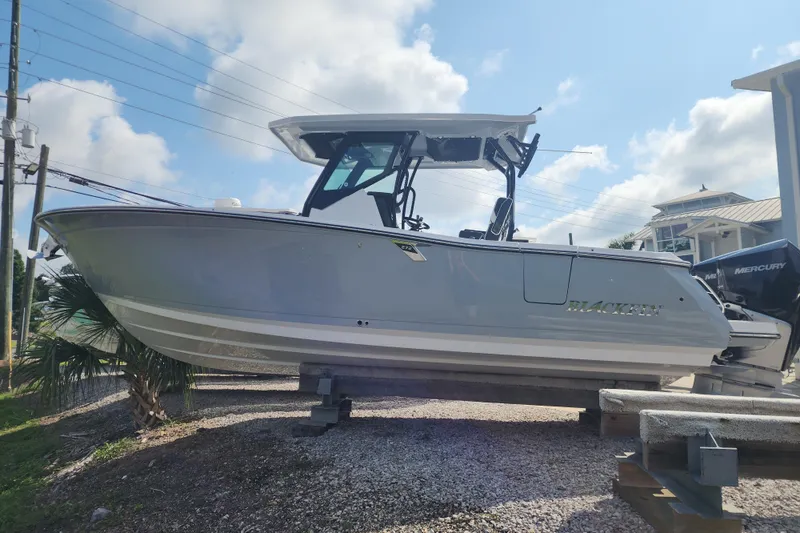 The Image of 2026 Blackfin 272 CC boat on display, featuring sleek design and Mercury engine. - 0
