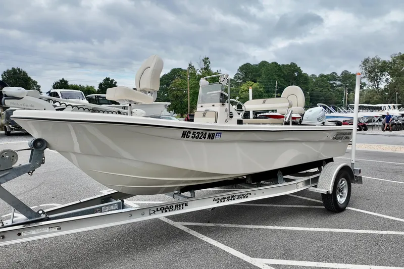 Slide: The Image of 2023 Carolina Skiff 178 boat on trailer in parking lot, cloudy sky background. - 10