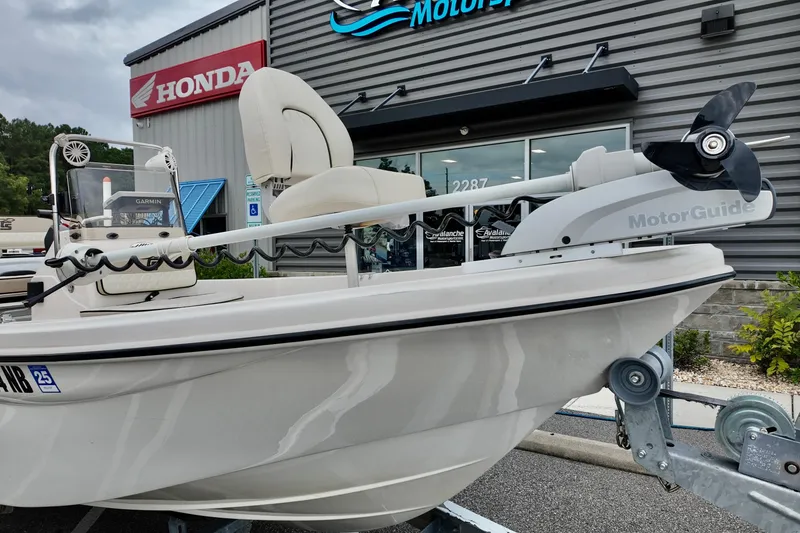 Slide: The Image of 2023 Carolina Skiff 178 boat with MotorGuide motor, displayed outside a dealership. - 11