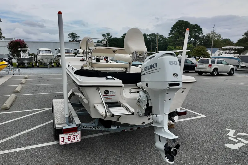 Slide: The Image of 2023 Carolina Skiff 178 boat with Suzuki outboard motor on a trailer in a parking lot. - 9