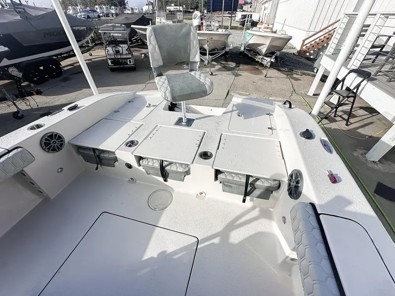 Slide: The Image of 2026 Carolina Skiff 22 Ultra Elite boat with T-top and seating, parked near a house. - 34