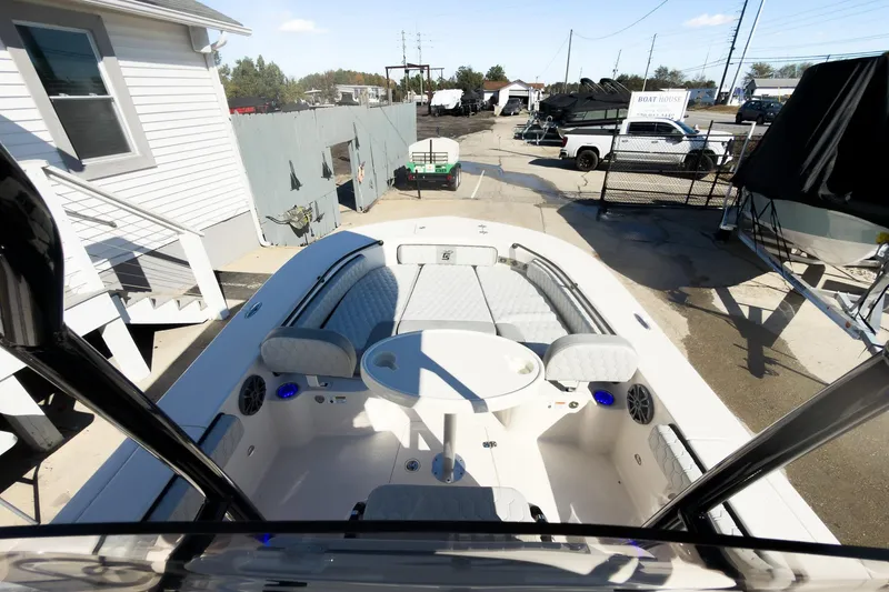 Slide: The Image of 2026 Carolina Skiff 22 Ultra Elite boat interior with seating and table, parked at a marina. - 55