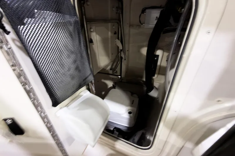 Slide: The Image of 2026 Carolina Skiff 22 Ultra Elite boat interior with storage compartment and portable toilet. - 90