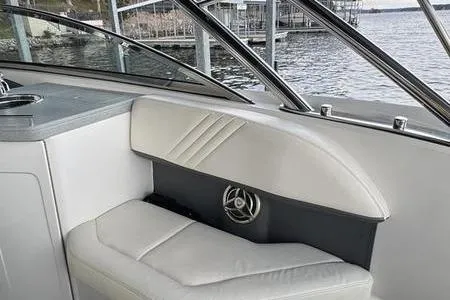 Slide: The Image of 2007 Cobalt 302 boat interior with white seating and speaker, dockside view. - 26