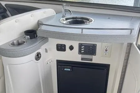 Slide: The Image of 2007 Cobalt 302 boat kitchenette with sink, mini fridge, and control panel. - 29