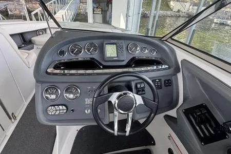 Slide: The Image of 2007 Cobalt 302 boat dashboard with steering wheel and control gauges. - 33