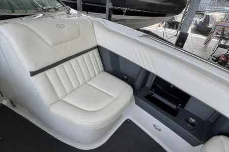 Slide: The Image of 2007 Cobalt 302 boat interior with white leather seating and storage compartment. - 34