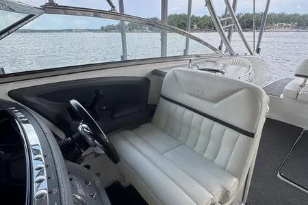 Slide: The Image of 2007 Cobalt 302 boat interior with white seating and steering wheel, overlooking serene water. - 35
