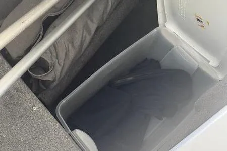 Slide: The Image of Storage compartment in a 2007 Cobalt 302 boat, featuring a cooler and fabric items. - 36