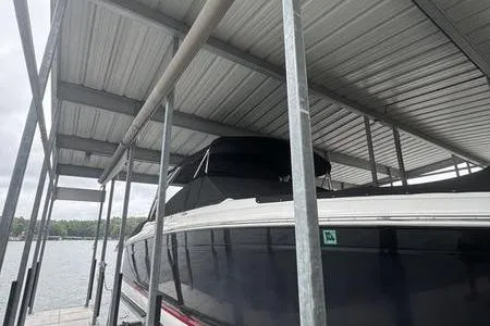 Slide: The Image of 2007 Cobalt 302 boat docked under metal canopy on a lake. - 6
