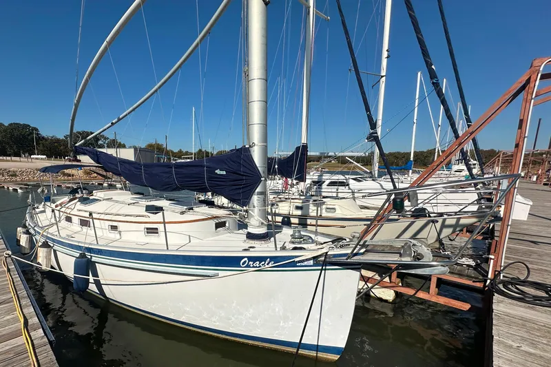 The Image of 1989 Nonsuch 36 sailboat docked at a marina under clear blue skies. - 0