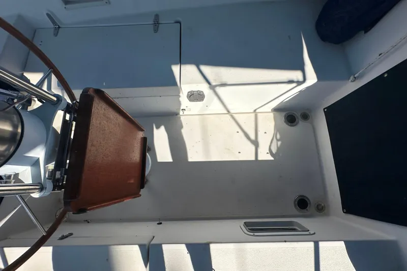Slide: The Image of 1989 Nonsuch 36 sailboat cockpit with wooden helm and clean white deck. - 12