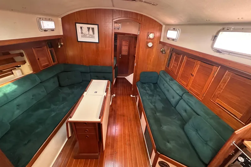 Slide: The Image of Interior of 1989 Nonsuch 36 sailboat with green seating and wooden finishes. - 18