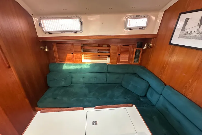 Slide: The Image of Interior of 1989 Nonsuch 36 sailboat with teal seating and wooden cabinetry. - 19