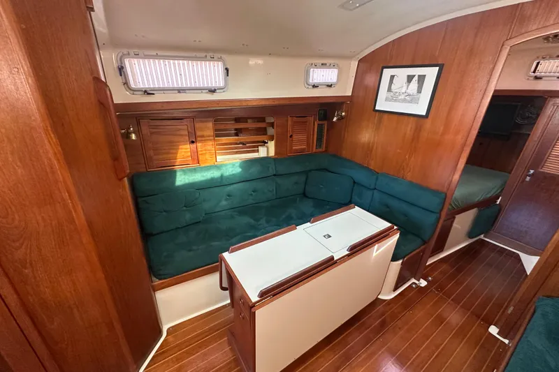Slide: The Image of Interior of 1989 Nonsuch 36 sailboat with green seating and wooden accents. - 20