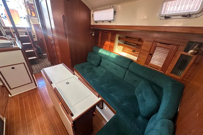 Slide: The Image of Interior of 1989 Nonsuch 36 sailboat with green sofa and wooden accents. - 23