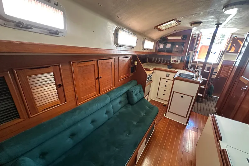 Slide: The Image of Interior of 1989 Nonsuch 36 sailboat with wooden cabinetry and green sofa. - 24