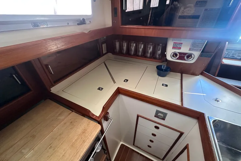 Slide: The Image of 1989 Nonsuch 36 yacht galley with wooden cabinetry and countertop. - 27