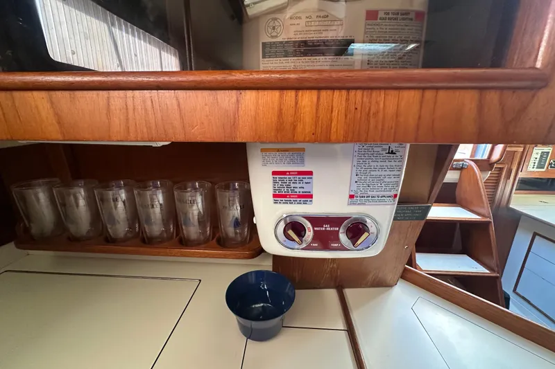 Slide: The Image of Interior of 1989 Nonsuch 36 sailboat with gas water heater and glass storage. - 28