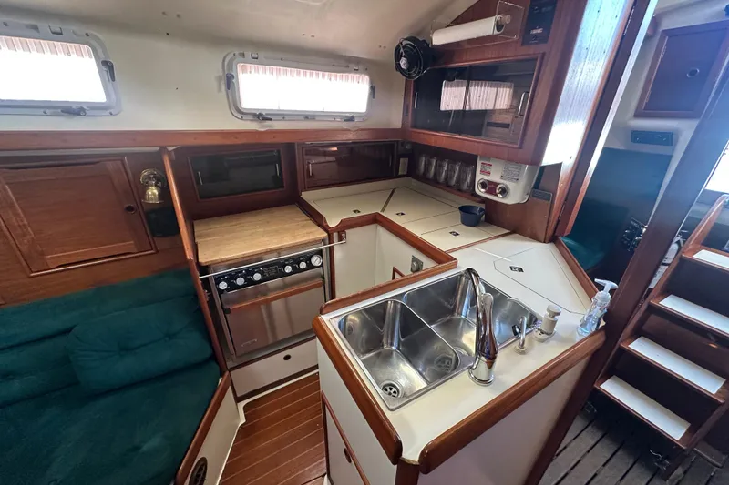 Slide: The Image of Interior of a 1989 Nonsuch 36 sailboat with kitchen and seating area. - 29