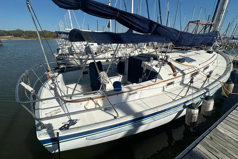 Slide: The Image of 1989 Nonsuch 36 sailboat docked at marina with blue canvas cover. - 3
