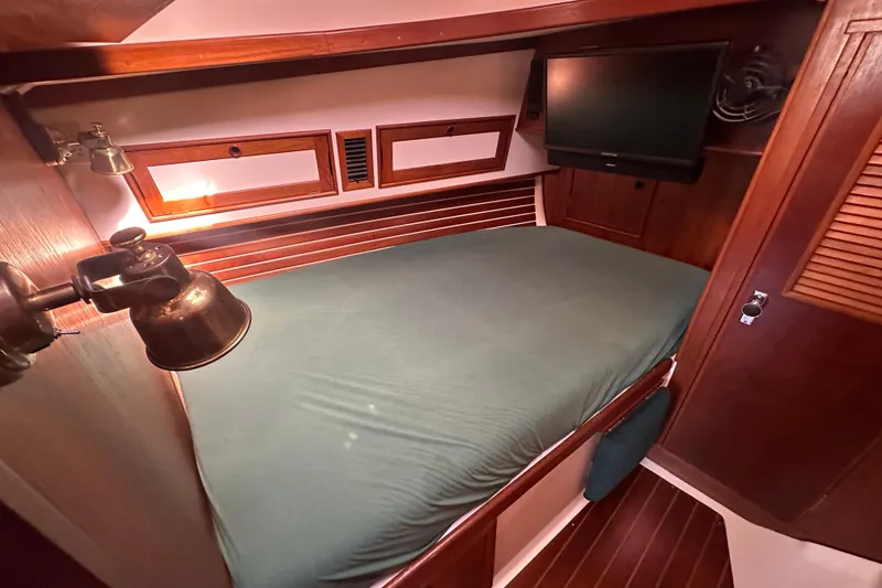 Slide: The Image of Cozy cabin interior of 1989 Nonsuch 36 sailboat with bed and TV. - 30