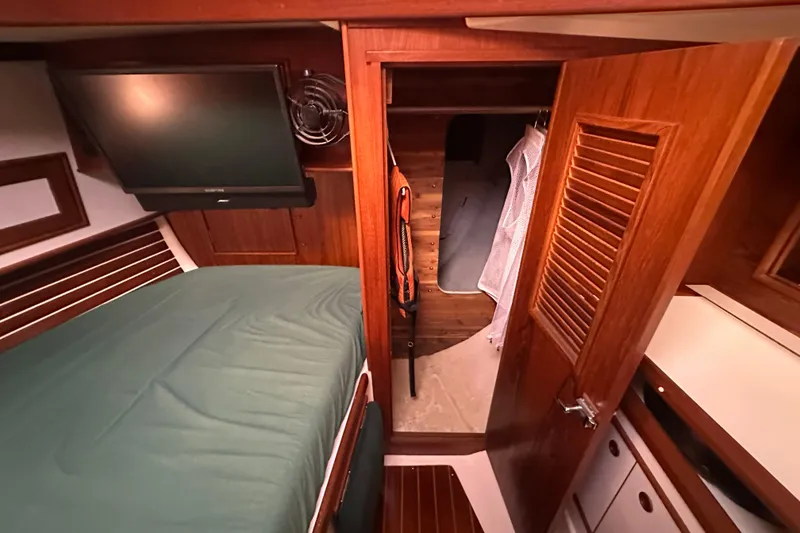 Slide: The Image of Interior of 1989 Nonsuch 36 sailboat with bed, TV, and wooden cabinetry. - 32