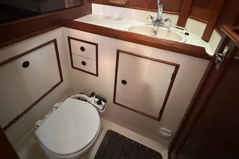 Slide: The Image of 1989 Nonsuch 36 yacht bathroom with wooden cabinetry and white fixtures. - 43