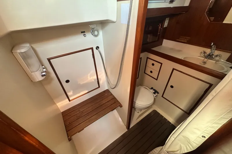 Slide: The Image of 1989 Nonsuch 36 yacht bathroom with shower, sink, and wooden accents. - 44