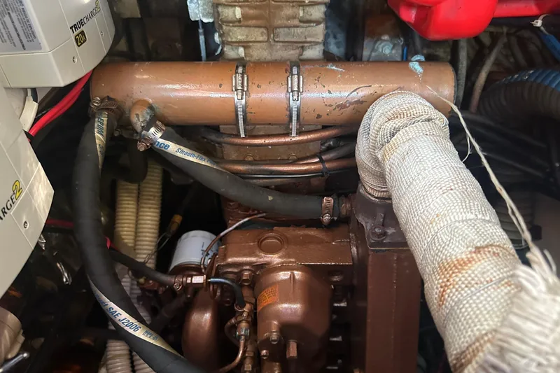 Slide: The Image of Engine compartment of a 1989 Nonsuch 36 sailboat, showing hoses and components. - 48