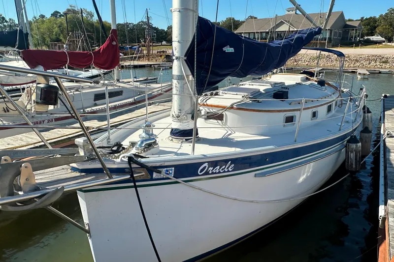 Slide: The Image of 1989 Nonsuch 36 sailboat docked at marina, featuring blue and white hull. - 5