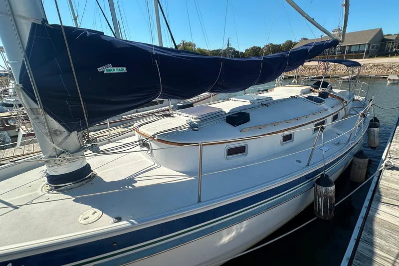 Slide: The Image of 1989 Nonsuch 36 sailboat docked, featuring a blue sail cover and spacious deck. - 6