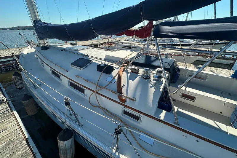 Slide: The Image of 1989 Nonsuch 36 sailboat docked at marina, featuring spacious deck and rigging. - 8