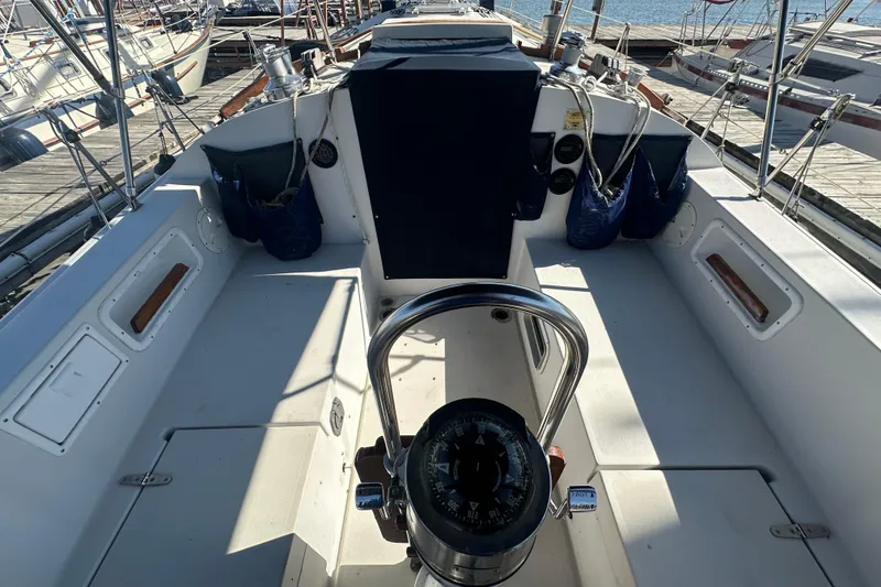 Slide: The Image of Cockpit of a 1989 Nonsuch 36 sailboat, featuring a steering wheel and compass. - 9