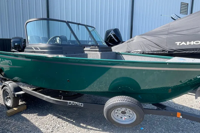 The Image of 2026 Lund 1650 Angler Sport boat on trailer, parked outdoors. - 1