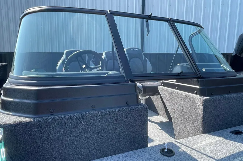 Slide: The Image of 2026 Lund 1650 Angler Sport boat interior with windshield and seating. - 11