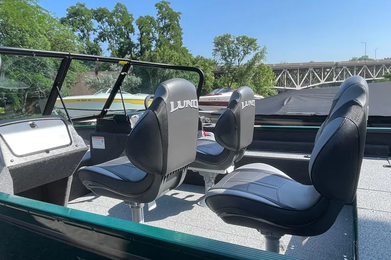 Slide: The Image of 2026 Lund 1650 Angler Sport boat interior with black seats and windshield. - 14