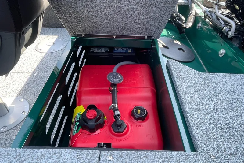 Slide: The Image of 2026 Lund 1650 Angler Sport boat with open storage compartment and red fuel tank. - 15