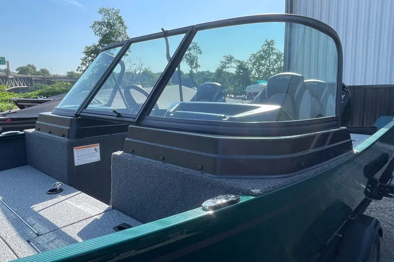 Slide: The Image of 2026 Lund 1650 Angler Sport boat with windshield, parked outdoors. - 18