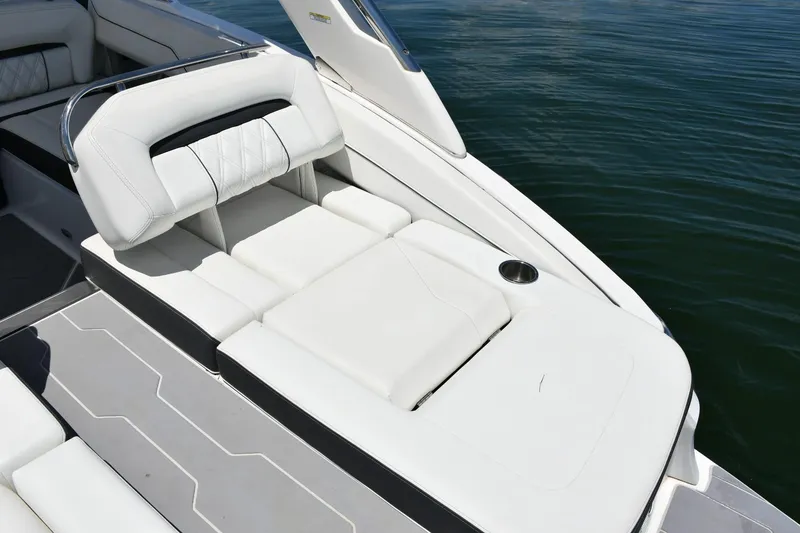 Slide: The Image of 2019 Regal LS4 boat with luxurious white seating and cup holder on calm water. - 10
