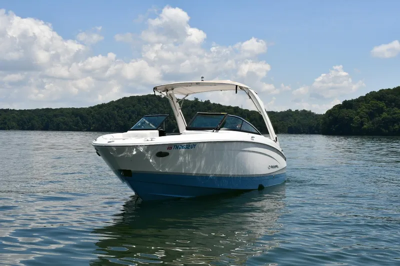 Slide: The Image of 2019 Regal LS4 boat on a serene lake with lush green hills. - 3