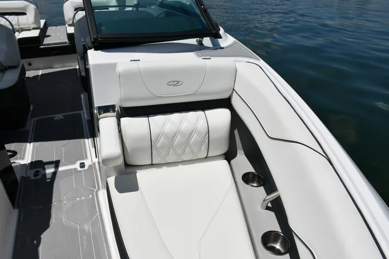 Slide: The Image of 2019 Regal LS4 boat interior with white seating and cup holders on a sunny day. - 8