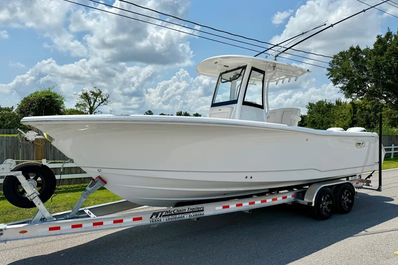 The Image of 2026 Sea Hunt Gamefish 27 Coffin Box boat on trailer, parked outdoors under a cloudy sky. - 1