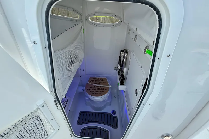 Slide: The Image of 2026 Sea Hunt Gamefish 27 Coffin Box interior with compact marine toilet and storage. - 14